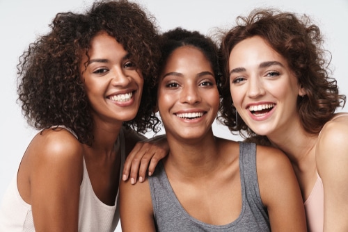 Retrato,de,tres,mujeres,jóvenes,multirraciales,de,pie,juntas,y,sonriendo - Opciones de blanqueamiento de encías para conseguir unas encías de aspecto saludable Dr. Alex Farnoosh